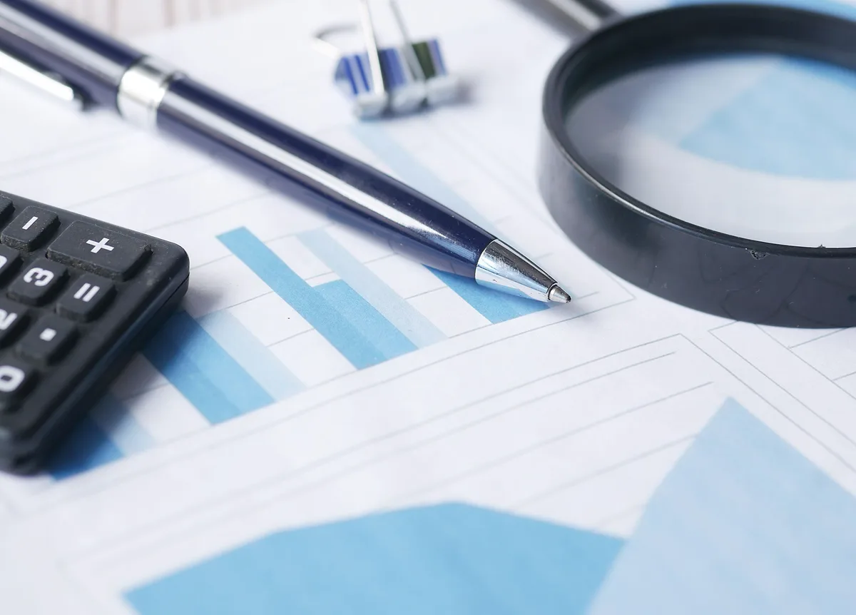 Financial statements and a magnifier on an auditor's desk